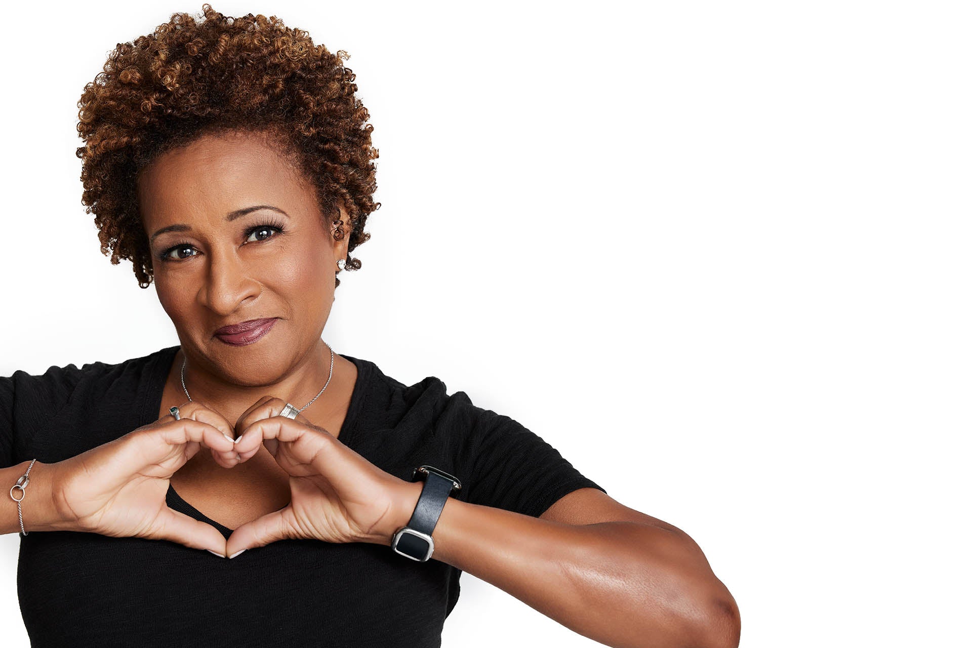 Photo of Wanda in a black shirt with her hands in the shape of a heart