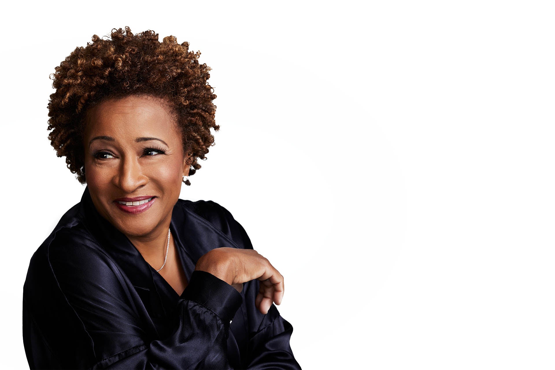 Photo of Wanda in a dark purple silk blouse sitting in a casual banter manner